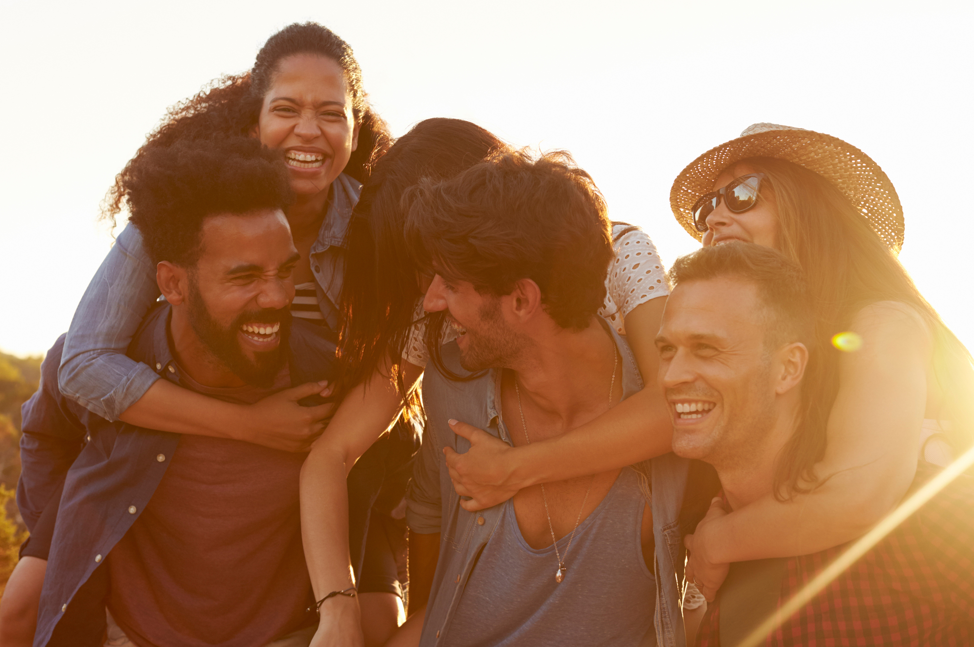 Group of friends playing piggy back outdoors