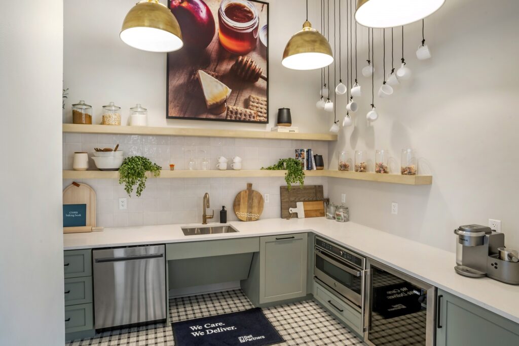 Indoor clubhouse kitchen with single sink, designer lighting, and steel appliances