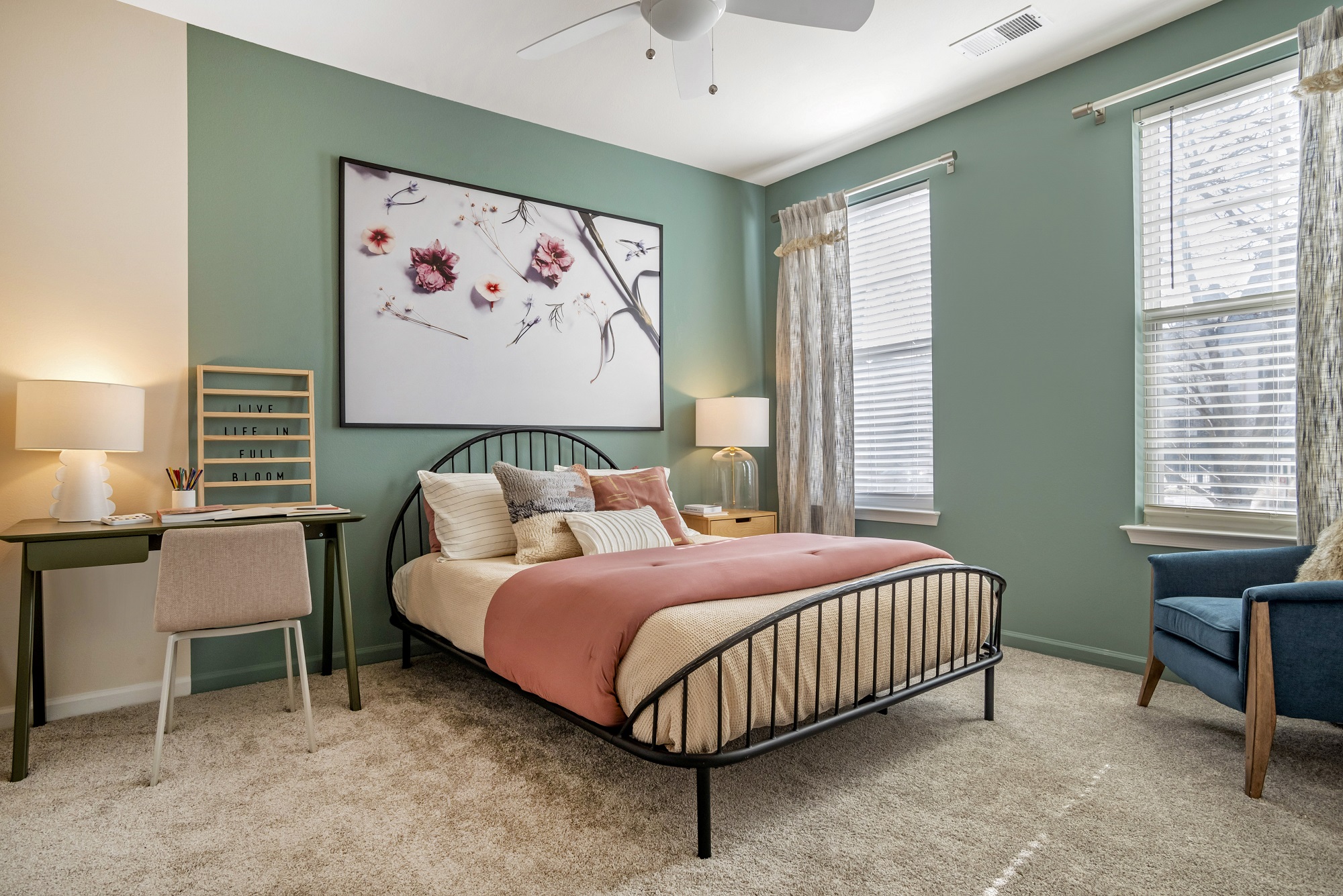 Bedroom with queen size bed, accent colored walls, lamps, windows, and carpet flooring