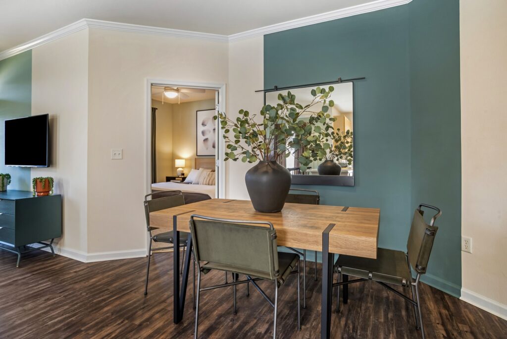 Dining room area with dining table, accent colored walls, open access to living room, and bedroom access