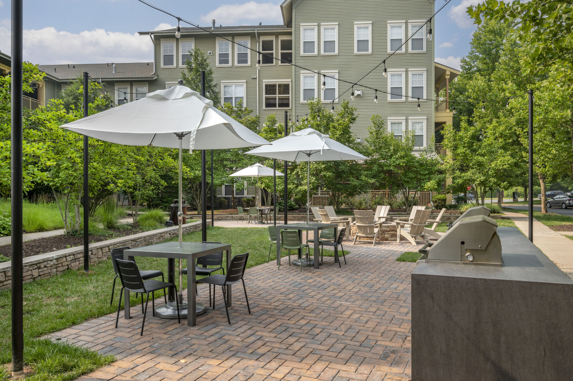 exterior kitchen with ample seating overlooking fire pit area